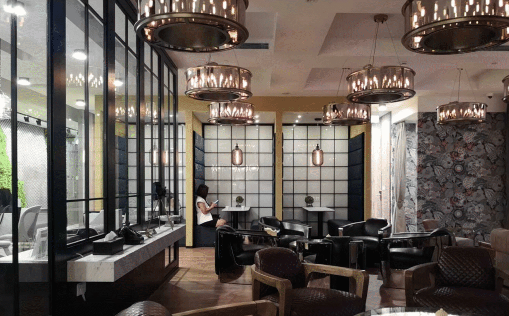 Elegant coworking lounge with vintage lighting, leather chairs, and private booth seating.